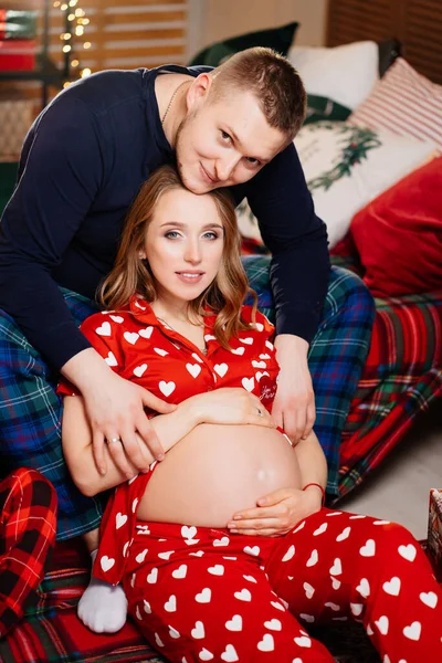 Aşık bir kadın ve erkek. Yeni yıl yatak odasında pijamalı bir aile. gebelik — Stok fotoğraf