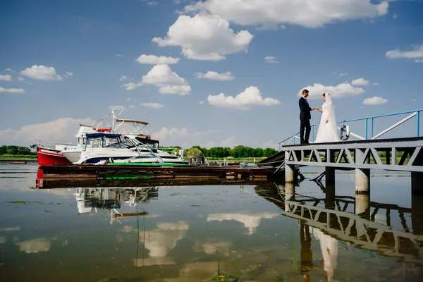 Bride and groom on the pier. wedding by the water or on a yacht. — Stock Photo, Image