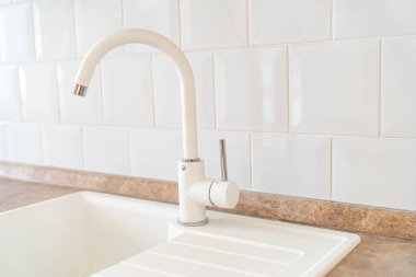 Beyaz lavabo ve mutfak musluğu. Ev için tesisat