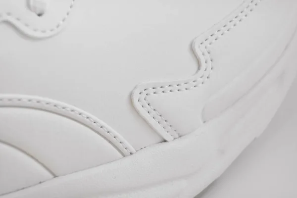 Fehér tornacipő egy része fehér alapon. — Stock Fotó