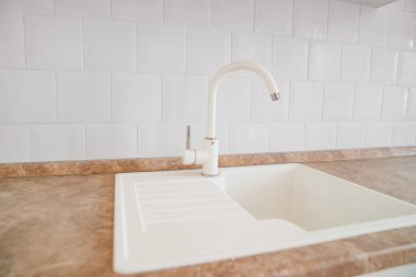 Beyaz lavabo ve mutfak musluğu. Ev için tesisat