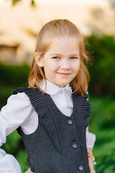 Una linda chica con un uniforme escolar gris. venta de ropa para escolares. —  Fotos de Stock