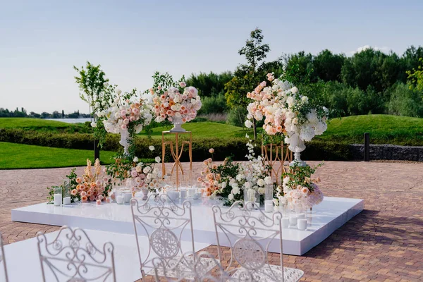 Çiçeklerin açık havasında, mumlarla birlikte düğün töreni.