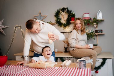 Mutlu aile geleneksel yemekleri yeni yıl hamurundan hazırlar. Annem hamile.