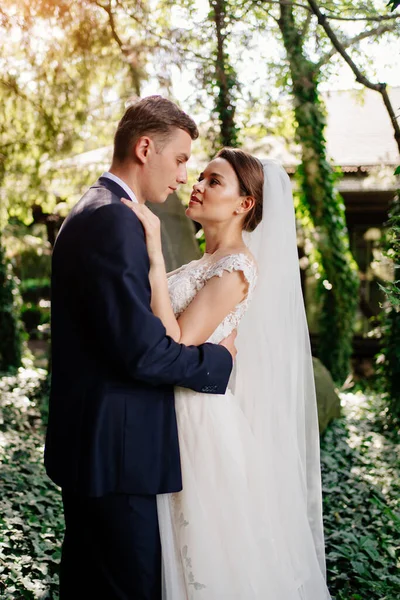 Heureux jeunes mariés par les arbres dans le park.bride et marié sur une promenade dans la nature — Photo