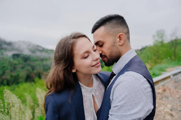 Braut und Bräutigam küssen sich zärtlich in der Natur. Romantik in der Beziehung — Stockfoto