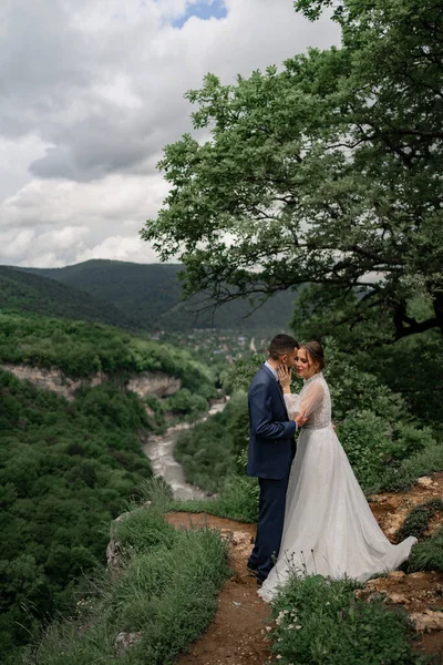 Une belle étreinte jeunes mariés dans une cérémonie de mariage dans les montagnes — Photo