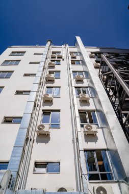 Pencereleri ve dış havalandırması olan çok katlı bir bina.. 