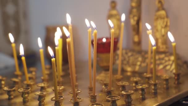 Bougies brûlantes dans l'église sur un stand d'or. — Video