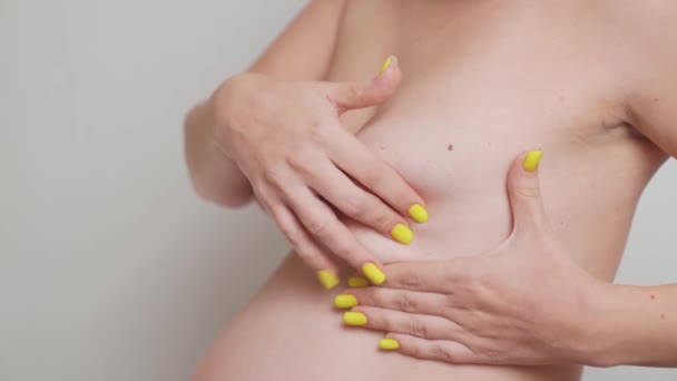 En gravid kvinna masserar brösten. Självdiagnos — Stockvideo