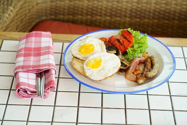 Traditionell frukost på en tallrik på ett bord med en rutig duk. — Stockfoto