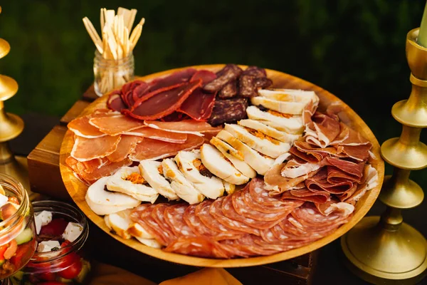 다양 한 고기자르기. 소시지, 미트로프, 둥근 나무 접시 위의 햄. — 스톡 사진
