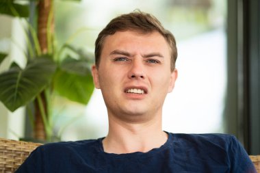 Huysuz yüzlü orta yaşlı bir adam bir şeyler söyler.. 