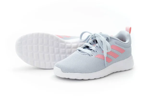 Grå sport sneakers med rosa ränder på en vit bakgrund. adidas — Stockfoto