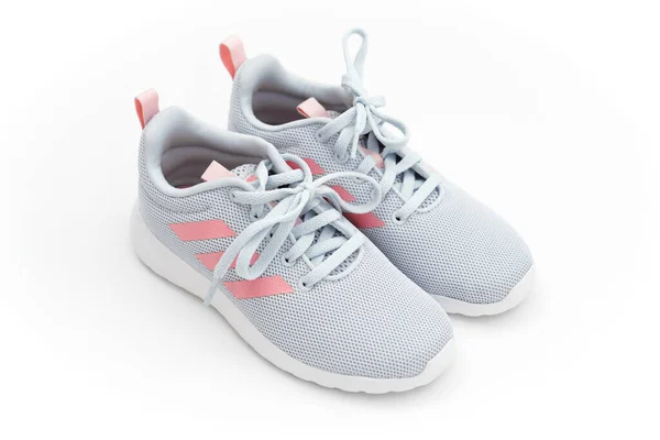 Grå sport sneakers med rosa ränder på en vit bakgrund. adidas — Stockfoto