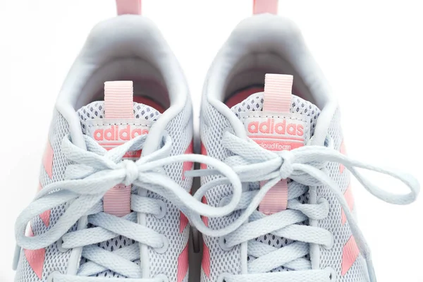 Parte de tênis de esportes cinza com listras rosa em um fundo branco. adidas — Fotografia de Stock