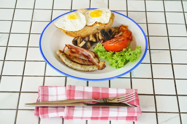 Traditionell frukost på en tallrik på ett bord med en rutig duk. — Stockfoto