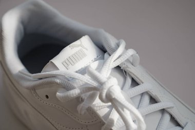puma. Beyaz arka planda bağcıkları olan beyaz spor ayakkabıları..