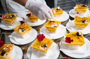 Yemek servisi. Garson masaya kremenki koyuyor ve süslüyor.. 