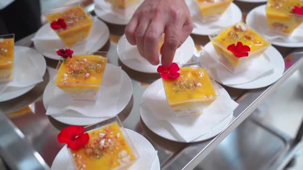 Catering. tjeneren lægger på bordet kremenki med dessert og dekorerer. – Stock-video
