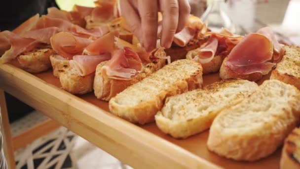 Las manos ponen rápidamente trozos de carne seca en la tostada. — Vídeos de Stock