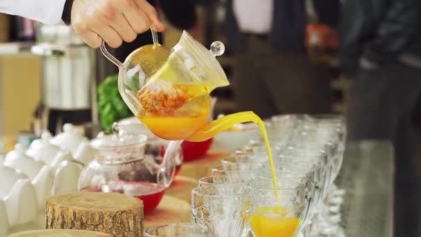 Een man schenkt hete thee in een glas. warme drank — Stockvideo