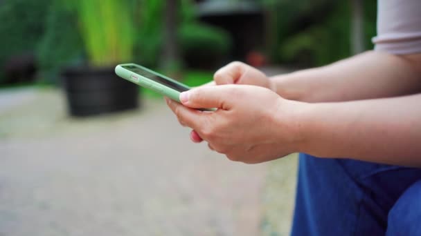 Frau hält Smartphone in der Hand und betrachtet Veröffentlichungen in sozialen Netzwerken — Stockvideo