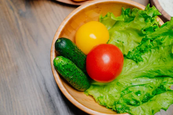 오이, 노랑 과 빨강 토마토, 상추가 들어 있는 나무 그릇. — 스톡 사진