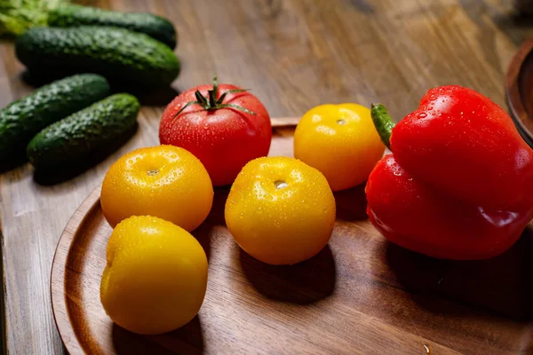 Yellow and red tomatoes and bell pepper with water drops. cucumbers on the table — Stock Photo, Image