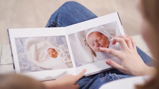 Ovanifrån. mor och dotter titta på fotobok från utsläpp av nyfödda barn — Stockvideo