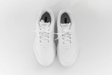 Beyaz arka planda bağcıkları olan beyaz spor ayakkabılar. İzole et. puma