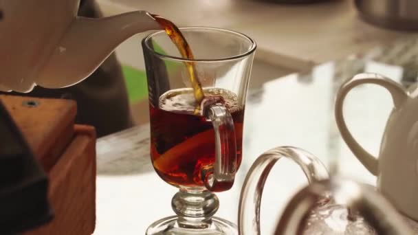 Un hombre vierte té caliente en un vaso. bebida caliente — Vídeo de stock