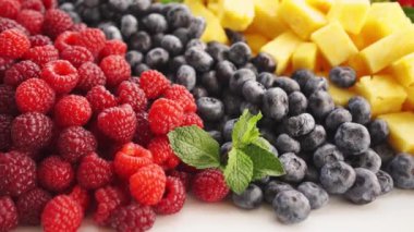 Çeşitli meyveler. Ahududu, yaban mersini, ananas ve çilek