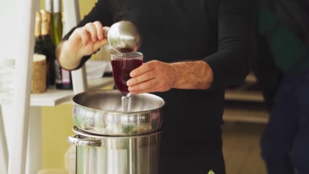 En man häller varmt glögg i ett glas. uppvärmningsdryck — Stockvideo