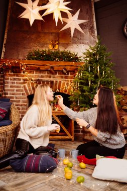 Mandalinalı neşeli arkadaşlar şöminede yeni yıl süslemeleri.
