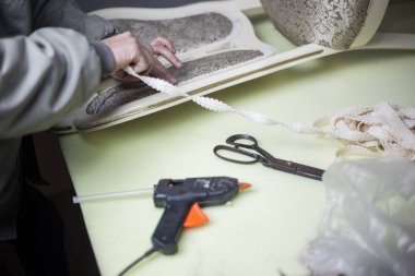 İşçi sıcak yapıştırıcı, bant ve makasla mobilya restorasyonu yapıyor