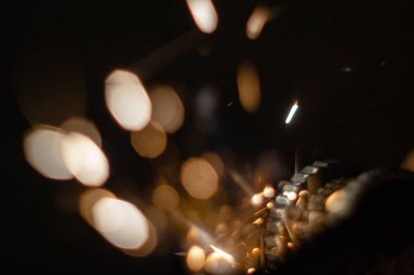 Siyah bir arkaplanda çakmaktan kıvılcımlar çakıyor.