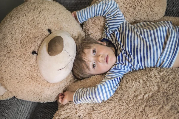 Kleines Kind hängt mit seinem Teddy herum Stockbild