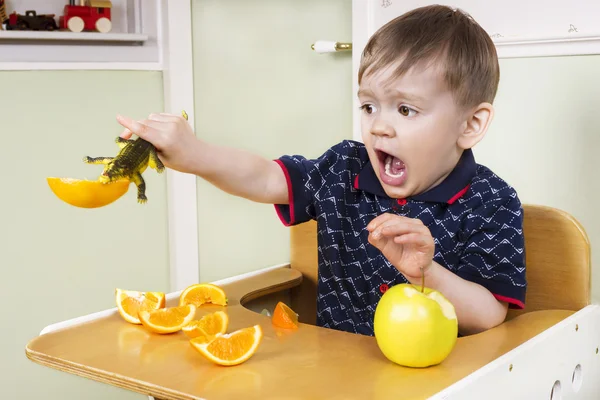 Kleiner Junge spielt mit seinen Früchten — Stockfoto