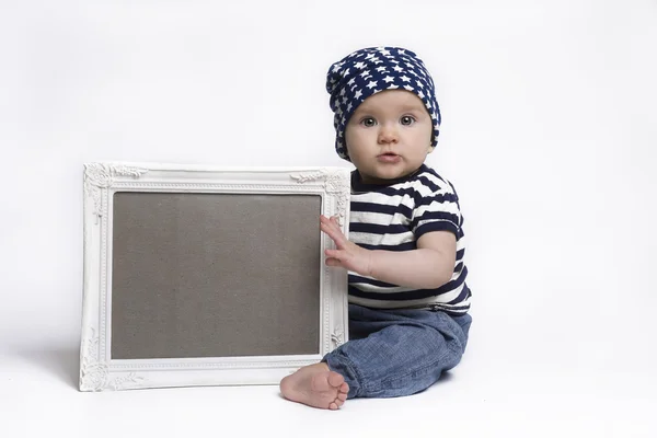 Lindo bebé sosteniendo un signo enmarcado en blanco Fotos de stock