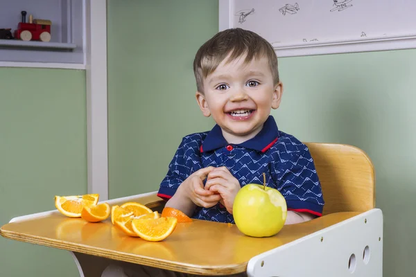 Glückliches Kleinkind isst Obst — Stockfoto