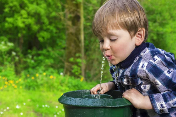 Lindo niño bebiendo de una fuente —  Fotos de Stock