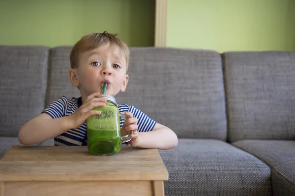 Χαριτωμένο παιδί πίνοντας ένα smoothie πράσινο — Φωτογραφία Αρχείου