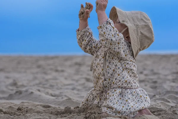 Niña jugando con arena en la playa — Foto de Stock