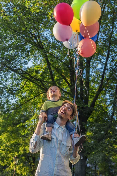 Pai e filho no parque com balões — Fotografia de Stock