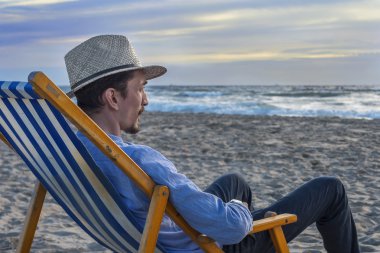 Adam kumsalda gün batımını izlemek