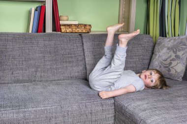 Küçük çocuk etrafında asılı kanepede