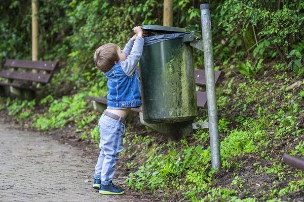 Liten pojke kastar skräp i soptunnan — Stockfoto