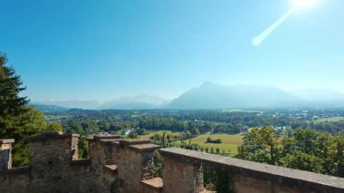 SALZBURG, AUSTRIA ECTOBER 03, 2025: yüksek açılı panoramik manzara ve Josefsturm 'un taş siperlerinden alınan vadi. Sahne yeşil tarlalara ve parlak, güneşli bir gökyüzünün altındaki uzak dağlara bakıyor..