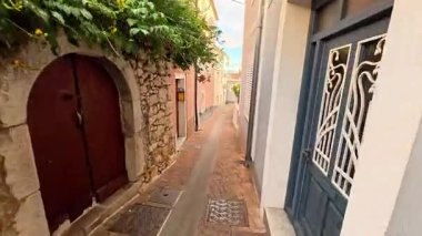 Crikvenica kasabasındaki renkli konutlar arasında dar ve temiz bir ara sokağa bakış açısı.